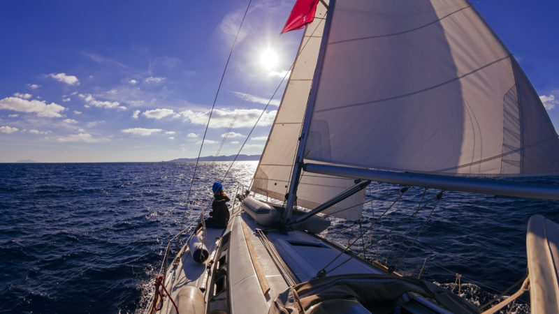 44233177 - sailing boat wide angle view in the sea at sunset, instagram toning